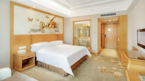 A hotel room with a bed, bedside table, TV, and a painting on the wall. - Vienna International Hotel Changsha Gaoqiao Branch (Changsha)