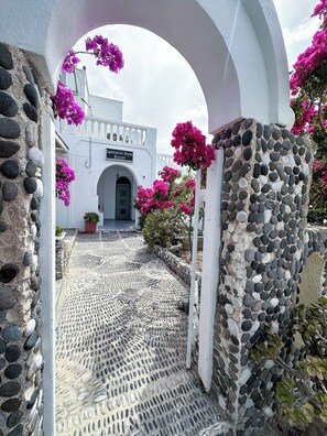 A stone pathway leading to a white building with a sign reading "Santorini Style Room". - Calypso Heaven (Santorini)