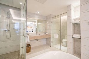 A modern bathroom with a glass shower enclosure, a large bathtub, and a vanity with a mirror. - Kunming HNA Flight Hotel (Kunming)