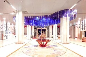 A spacious lobby with a central round table, a chandelier, and a reception desk. - Kunming HNA Flight Hotel (Kunming)