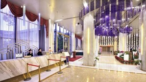 Eine moderne Hotelhalle mit einer Marmor-Rezeption, einem roten Teppich und einem großen Fenster mit Vorhängen.