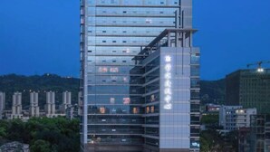 A modern high-rise building with multiple floors, large windows, and a prominent sign on the side. - CQ Second Normal University Academic Exchange Center Hotel (Chongqing)