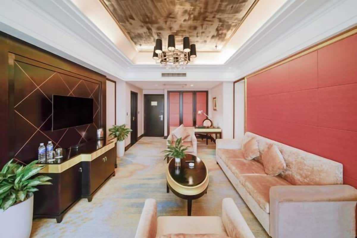 A modern living room with a sofa, a coffee table, and a TV on a cabinet.