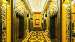 A luxurious hallway with ornate gold and black decor, a central chandelier, and a framed picture on the wall. - CQ Second Normal University Academic Exchange Center Hotel (Chongqing)