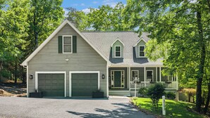A two-story house with a garage, a front porch, and a small front yard. - 3800 sq ft of Fun! Sleeps 14 • Hot Tub • Pool Table • PAC-Man • Foosball  (McGaheysville)
