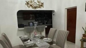 A dining area with a marble floor, a table set for four, and a decorative wall piece above the table. - Cozy 2-bedroom stay with fireplace, AC, Wi-Fi and Comfort (Spanish Town)