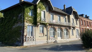 A historic building with a prominent balcony, large windows, and a brick facade. - Le Clos de Lignières : Chez Marguerite (Lignières-Châtelain)