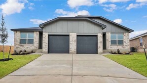 A two-story building with a garage, a brick facade, and a flat roof. - Peaceful Stay Near Fort Cavazos (Copperas Cove)