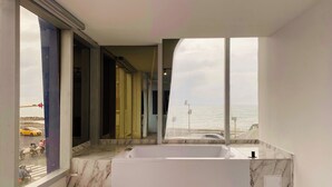 Une salle de bain moderne avec une grande baignoire et vue sur la mer.