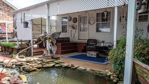 A rustic outdoor area with a pond, wooden steps, and a covered seating area. - Charming 2-bedroom house in fabulous Breaux Bridge with WiFi, AC (Breaux Bridge)