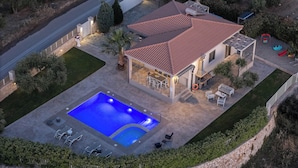 Une propriété résidentielle dotée d’une piscine, d’un espace extérieur aménagé et d’un patio couvert.