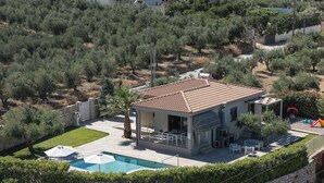 Une propriété résidentielle dotée d’une piscine, de mobilier de jardin et offrant une vue sur les maisons environnantes.