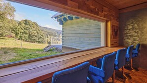 A wooden interior with a large window overlooking a forested area. - Sunny, stylish studio in the mountains (Královéhradecký kraj)