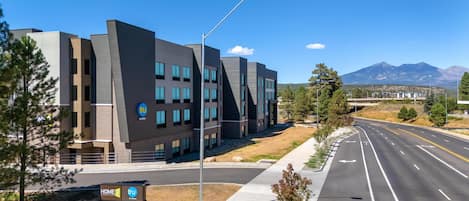 A modern hotel building with a flat roof, multiple windows, and a sign indicating it is a Tru hotel.