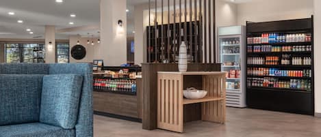 A modern interior with a seating area, a counter with beverages, and a display of bottled water.