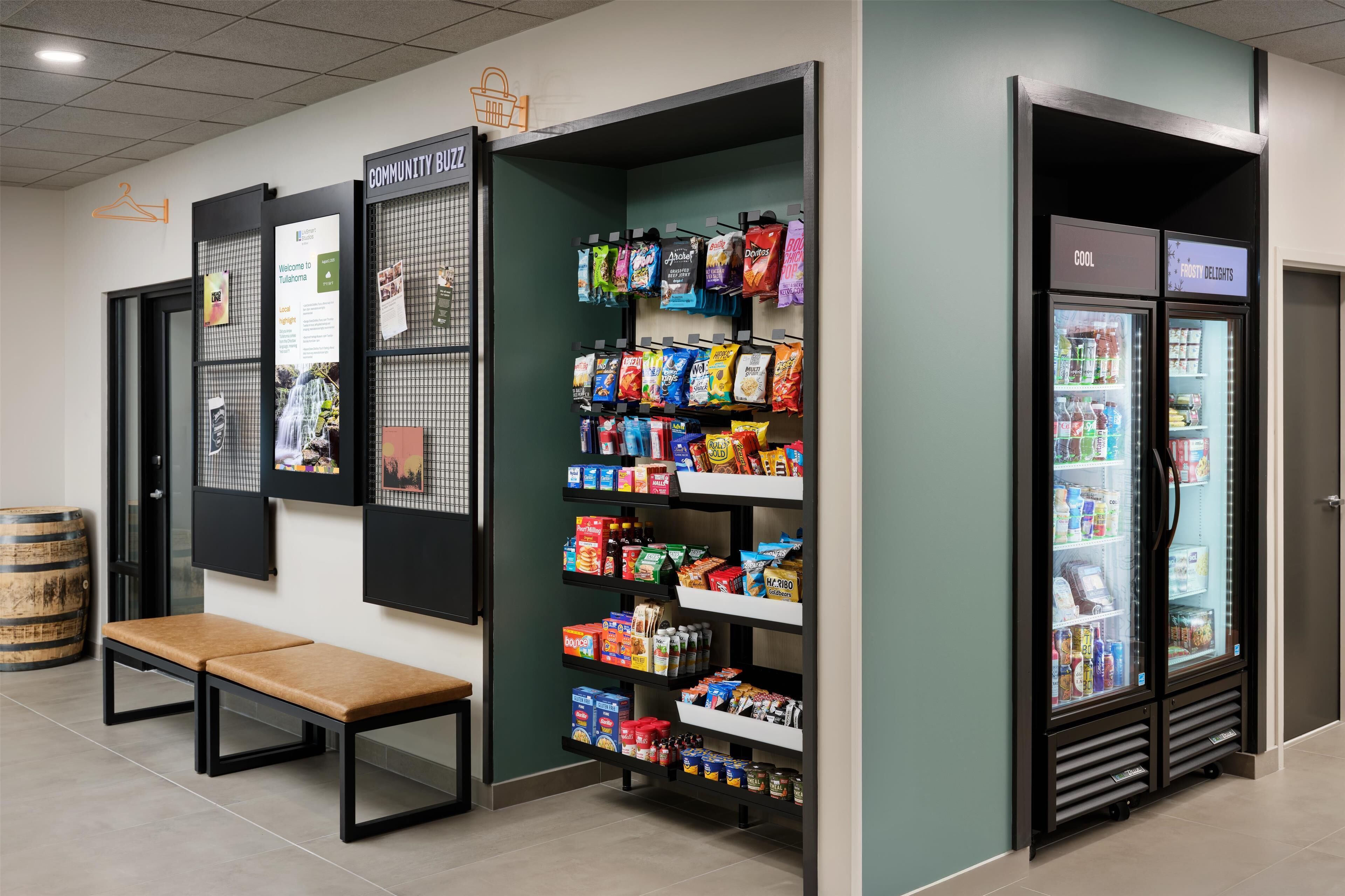 Un área de venta de aperitivos con diversas opciones envaseladas y una sección refrigerada con bebidas.