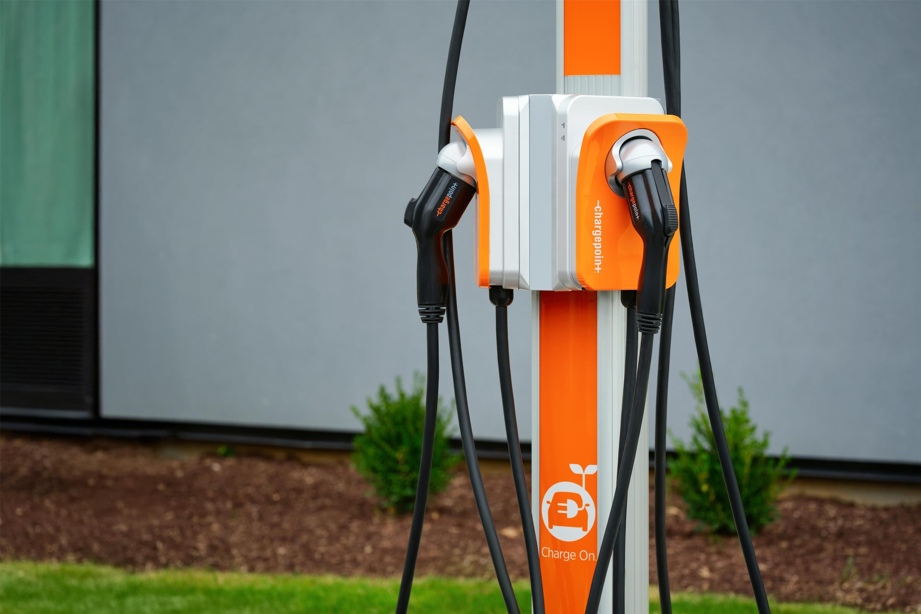 An electric vehicle charging station with two charging cables connected to it.