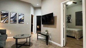 A modern living room with a sofa, a coffee table, and abstract art on the wall. - Luxe Retreat- Private Pool -BBQ- Peaceful Retreat- Comfort-Relax-Prime Location (Mesa)