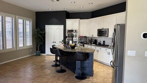A modern kitchen with white cabinets, a granite countertop, and stainless steel appliances. - Luxe Retreat- Private Pool -BBQ- Peaceful Retreat- Comfort-Relax-Prime Location (Mesa)