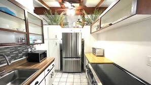 A compact kitchen with a microwave, stove, refrigerator, and toaster.