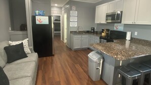 A modern kitchen with white cabinets, a granite countertop, and stainless steel appliances. - Blue crab house boat,Wi-Fi,Ice machine,sleeps 8,perfect place to fish🐠🎣🐟 (Venice)