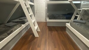 A room with bunk beds, a door, and a wooden floor. - Blue crab house boat,Wi-Fi,Ice machine,sleeps 8,perfect place to fish🐠🎣🐟 (Venice)