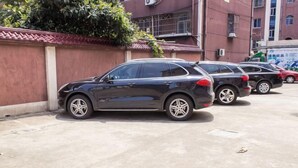 A parking area with several cars parked. - Xinsihai Hotel (Ningbo)