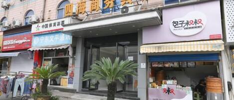 Un edificio comercial con varias fachadas, incluyendo un letrero visible para un negocio llamado '四海商务宾馆'.