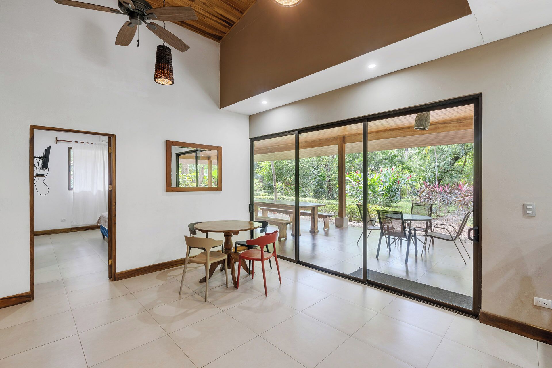 A spacious room with a large sliding glass door leading to an outdoor patio with a table and chairs.