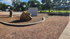 A park with a basketball court, a picnic area, and a covered seating area.