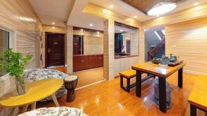 Un interior moderno con suelo de madera, una zona de comedor con mesa y sillas, una escalera y una planta.