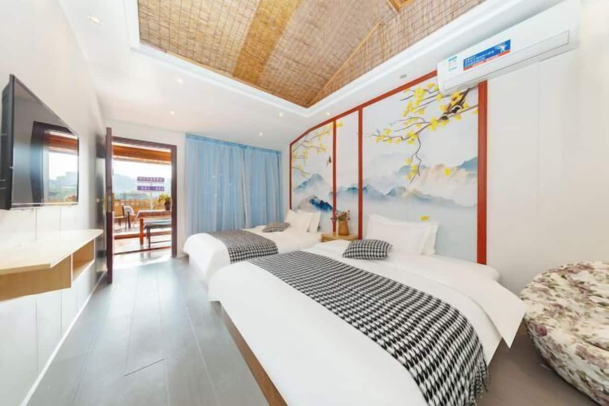Une chambre d’hôtel avec un grand lit, un bureau, une télévision et une fresque murale.