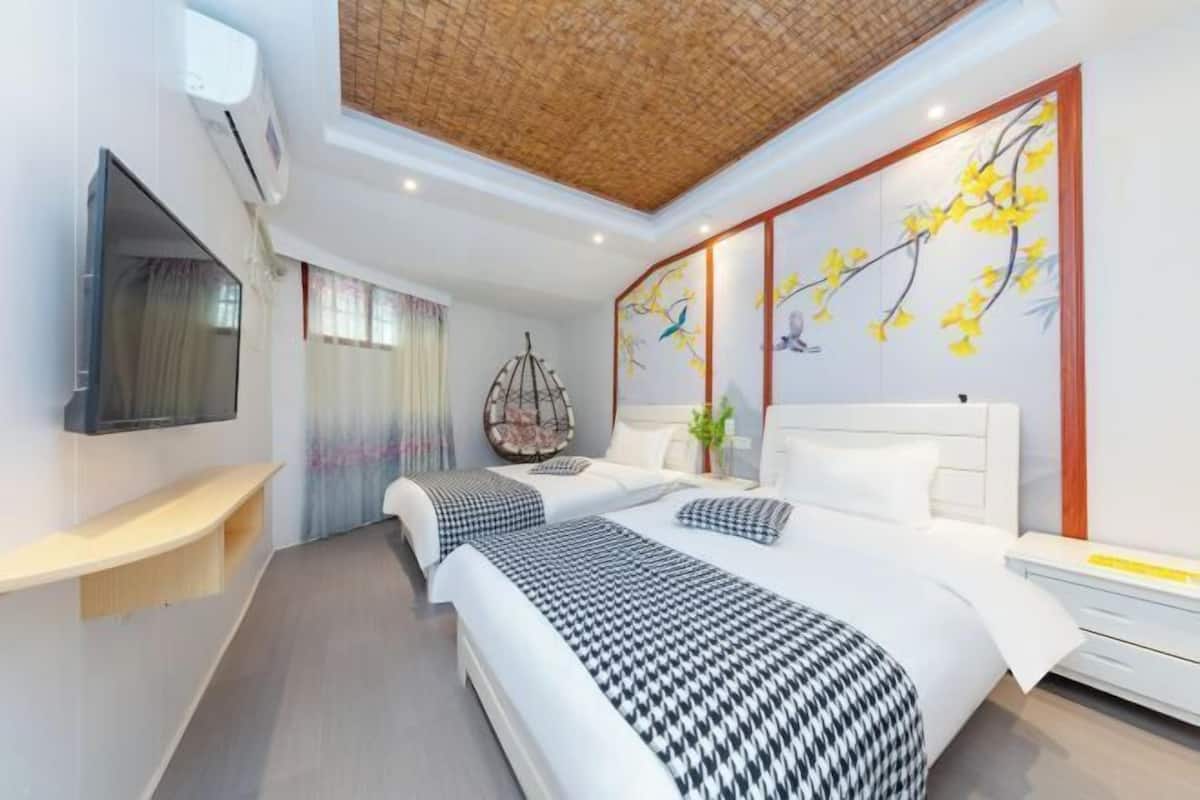 Une chambre d’hôtel moderne avec un grand lit, un téléviseur fixé au mur et un panneau décoratif mural.