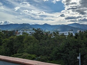 A mountainous landscape with buildings and trees. - CAVE (Medellín)