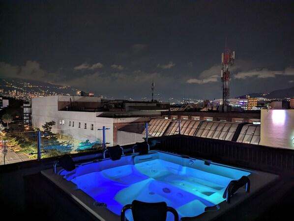 A rooftop jacuzzi with a cityscape view at night. - CAVE (Medellín)