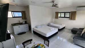 A compact hotel room with two beds, a sofa, a dining table, and a kitchenette. - Fugalei Motel (Apia)