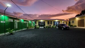 A hotel with a reception area, a car parked in front, and a gated entrance. - Fugalei Motel (Apia)
