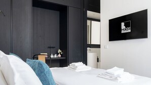 A modern hotel room with a bed, a desk, and a mirror. - Penthouse apartment 5.BMORE (Milano)