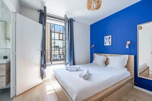 A bedroom with a bed, a window with curtains, a bathroom with a mirror, and a balcony. - 10min from Paris | Close to Shops/ 8min from Metro (Boulogne-Billancourt)
