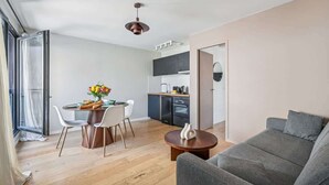 A modern apartment with a dining area, kitchen, and living space.