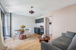 Apartamento moderno com sala de jantar, cozinha e área de estar.