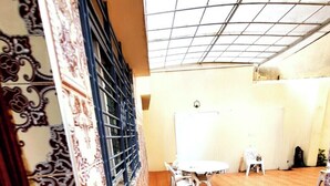 A room with a patterned floor, a white table with chairs, and a decorative wall with intricate designs.