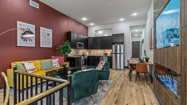 A modern kitchen with dark cabinets, a microwave, and a refrigerator. - Old City History Kid-Friendly (Philadelphia)