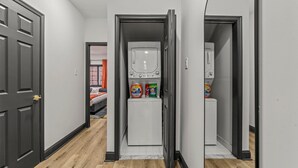 A hallway with a laundry area featuring a washing machine and detergent bottles. - Old City History Kid-Friendly (Philadelphia)