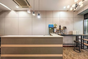 A reception desk with a counter, overhead lighting, and a wall-mounted information board. - Jinghu Hotel (Hangzhou Hefang Street Branch) (Hangzhou)
