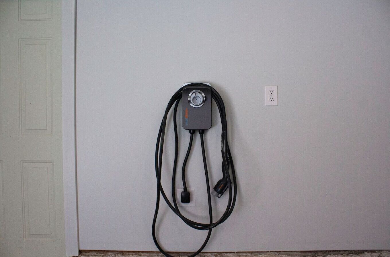A wall-mounted electrical outlet with a power cord plugged in.