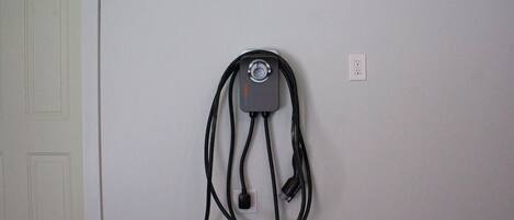 A wall-mounted electrical outlet with a power cord plugged in.