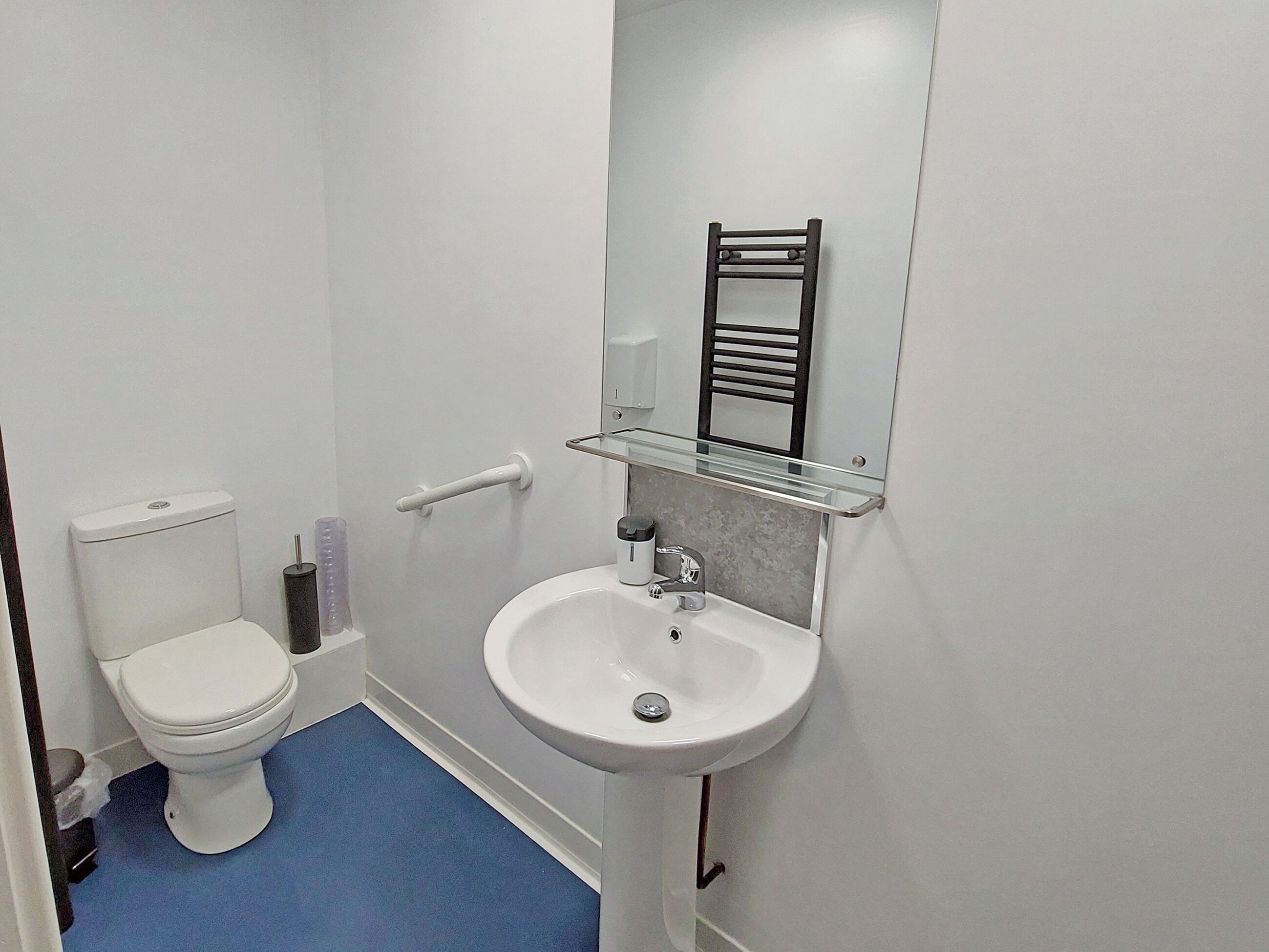 Une petite salle de bain avec des toilettes, un lavabo et un miroir.
