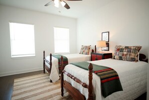 A bedroom with two beds, a ceiling fan, a nightstand with a lamp, and a window with blinds. - Luxurious Property in the Heart of Oxford (Oxford)
