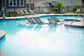 A swimming pool with lounge chairs and a safety sign. - Luxurious Property in the Heart of Oxford (Oxford)